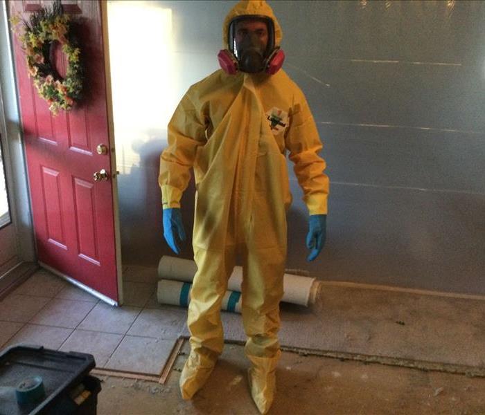 male in yellow personal protective equipment suit with booties and mask