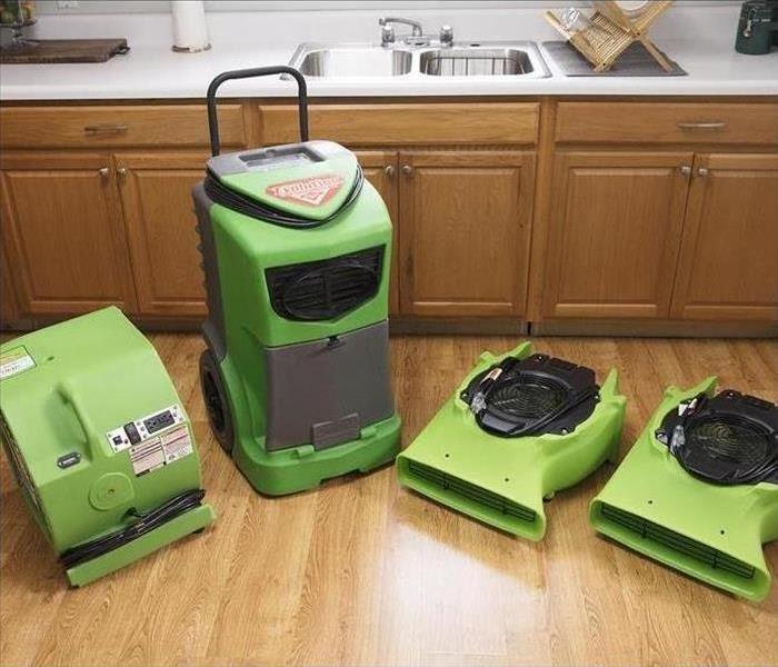 four green servpro machines extracting water in kitchen sub floor vinyl flooring, certified restoration near me near sac