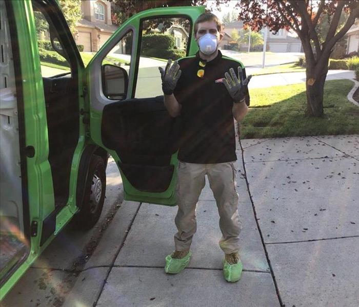 male in front of servpro vehicle with ppe gear, gloves, respirator mask, covid cleaning near sacramento, biohazard cleaning 