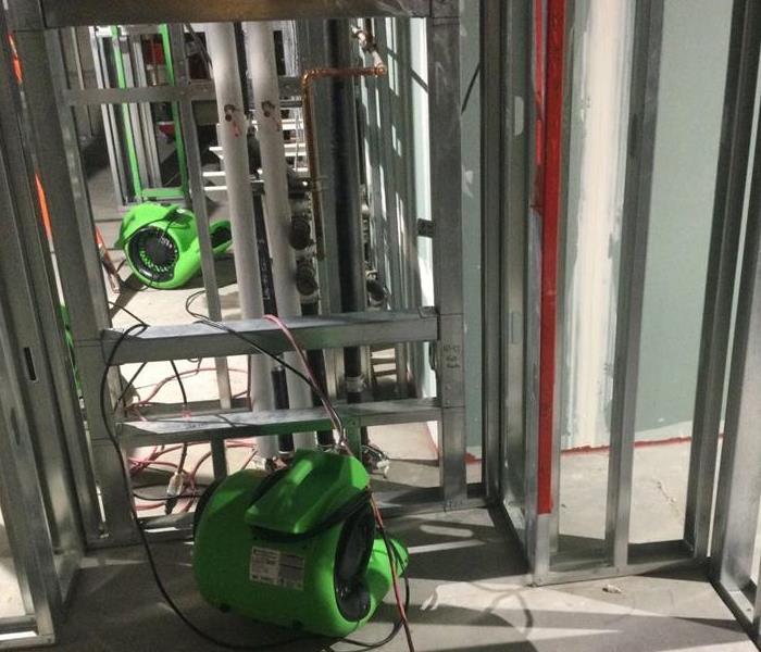 green air movers in a metal framing structure commercial building in Sacramento for water damage