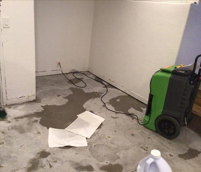 gray basement concrete water damage with servpro green machine to extract and dry water near wilhaggin near by near me sac 